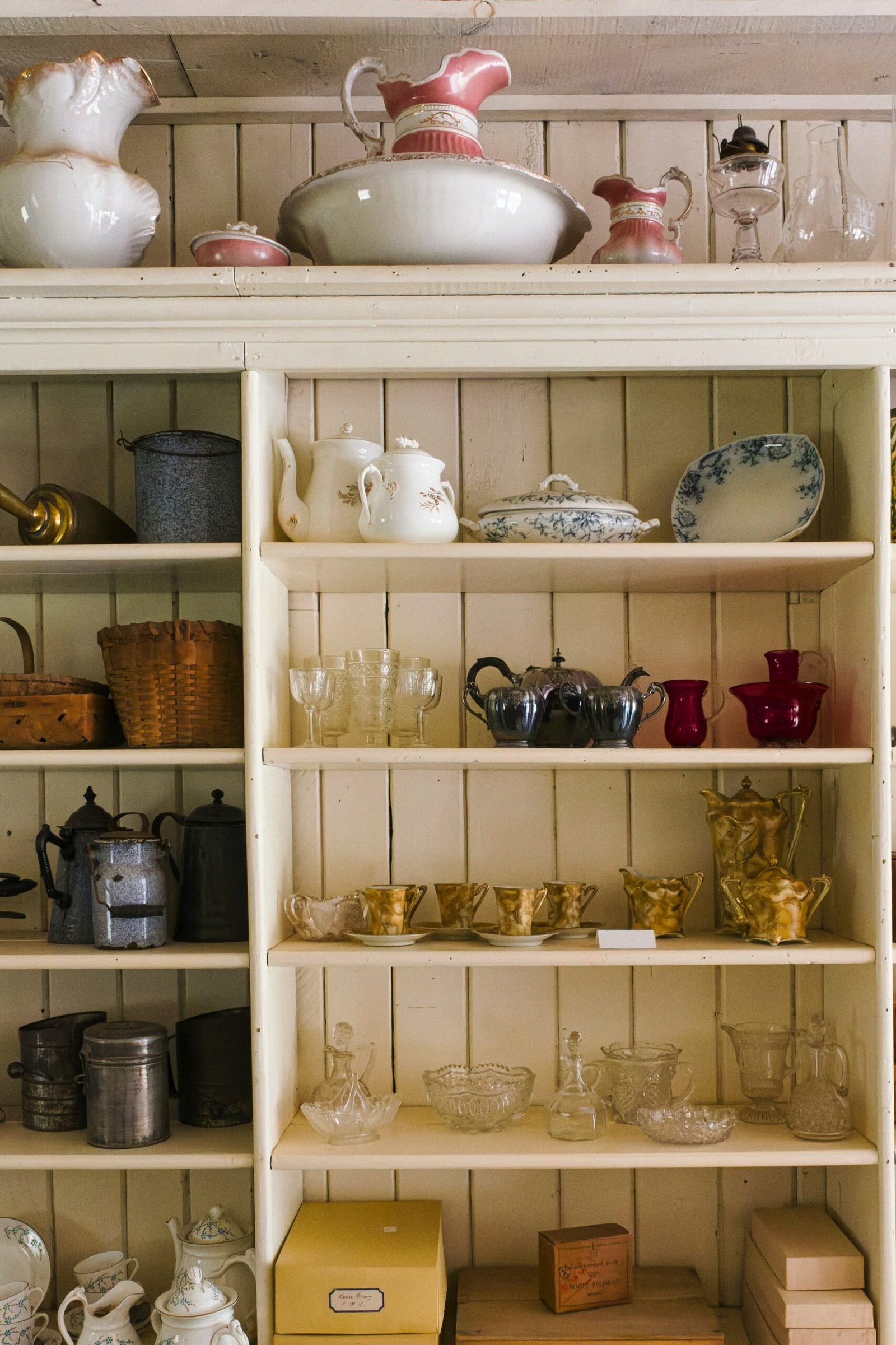 a white shelf filled with lots of dishes and cups